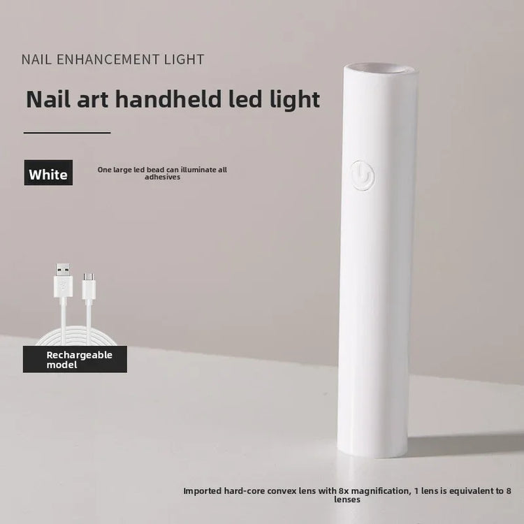 White rechargeable handheld LED nail art curing light with USB charging cable.